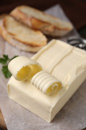 Photo of Tasty butter and slices of bread on table, closeup