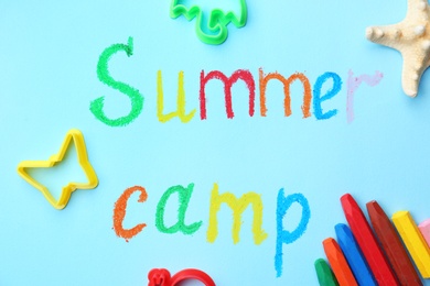 Photo of Flat lay composition with words SUMMER CAMP and crayons on color background
