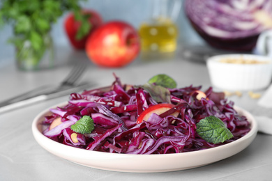 Photo of Fresh red cabbage salad served on light grey table