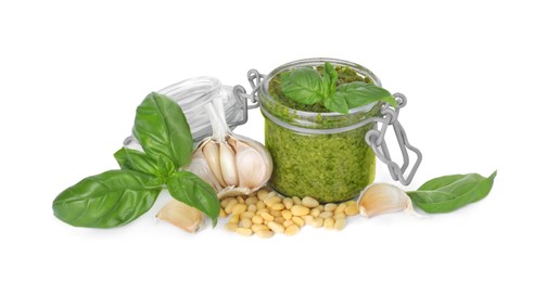 Delicious pesto sauce in jar and ingredients isolated on white