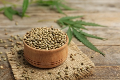 Photo of Bowl of hemp seeds on wooden table