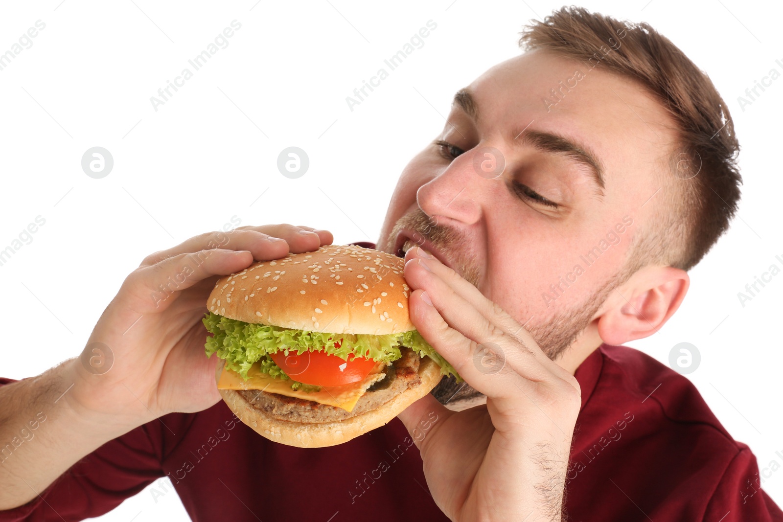 Photo of Young man eating tasty burger on white background