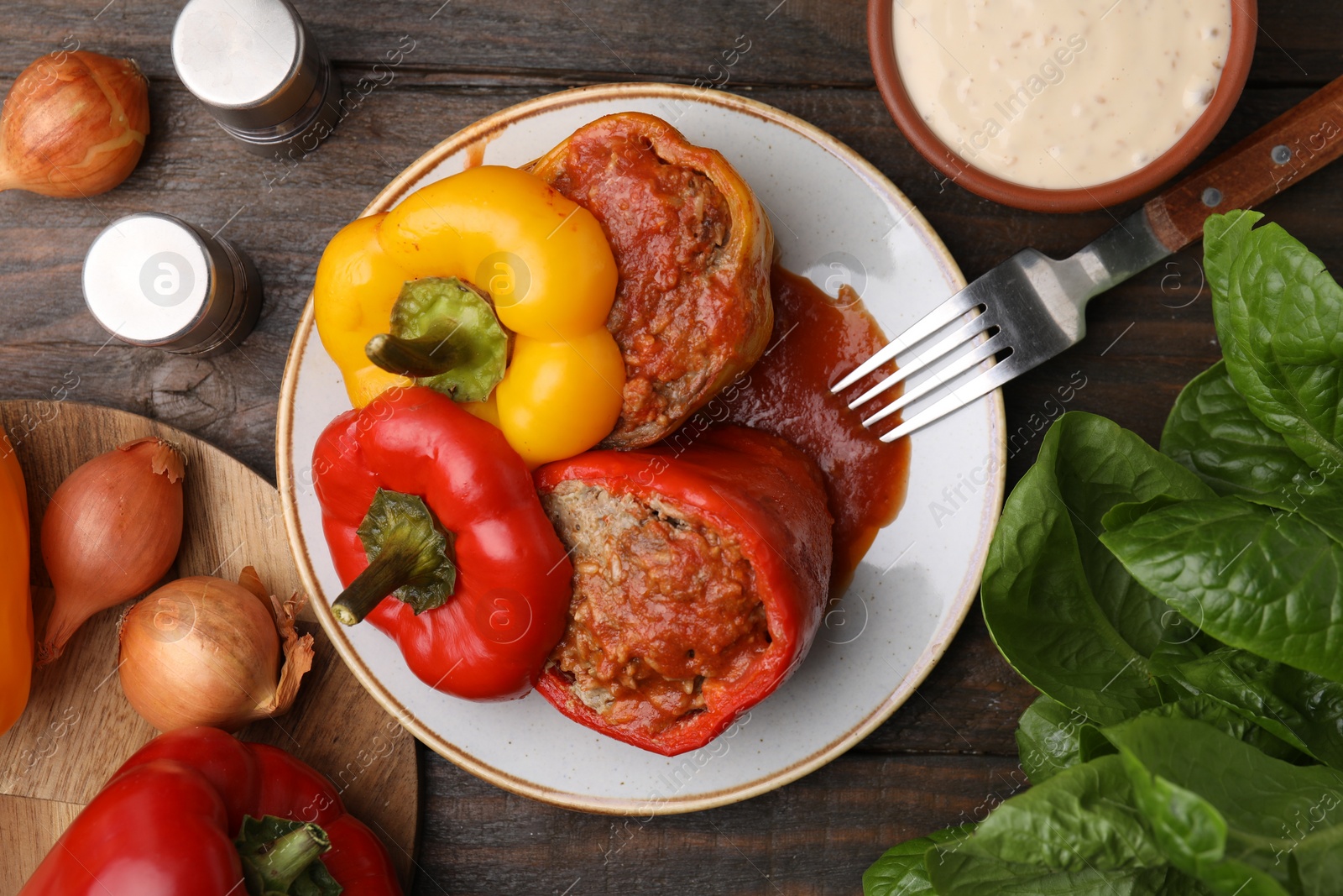 Photo of Delicious stuffed bell peppers served on wooden table, flat lay