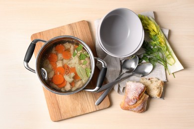 Photo of Delicious vegetable bouillon served on wooden table, flat lay