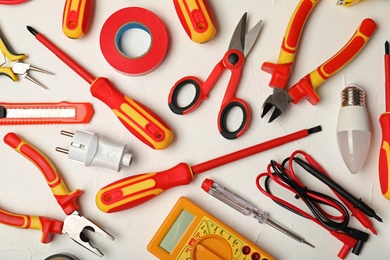 Flat lay composition with electrician's tools on light background