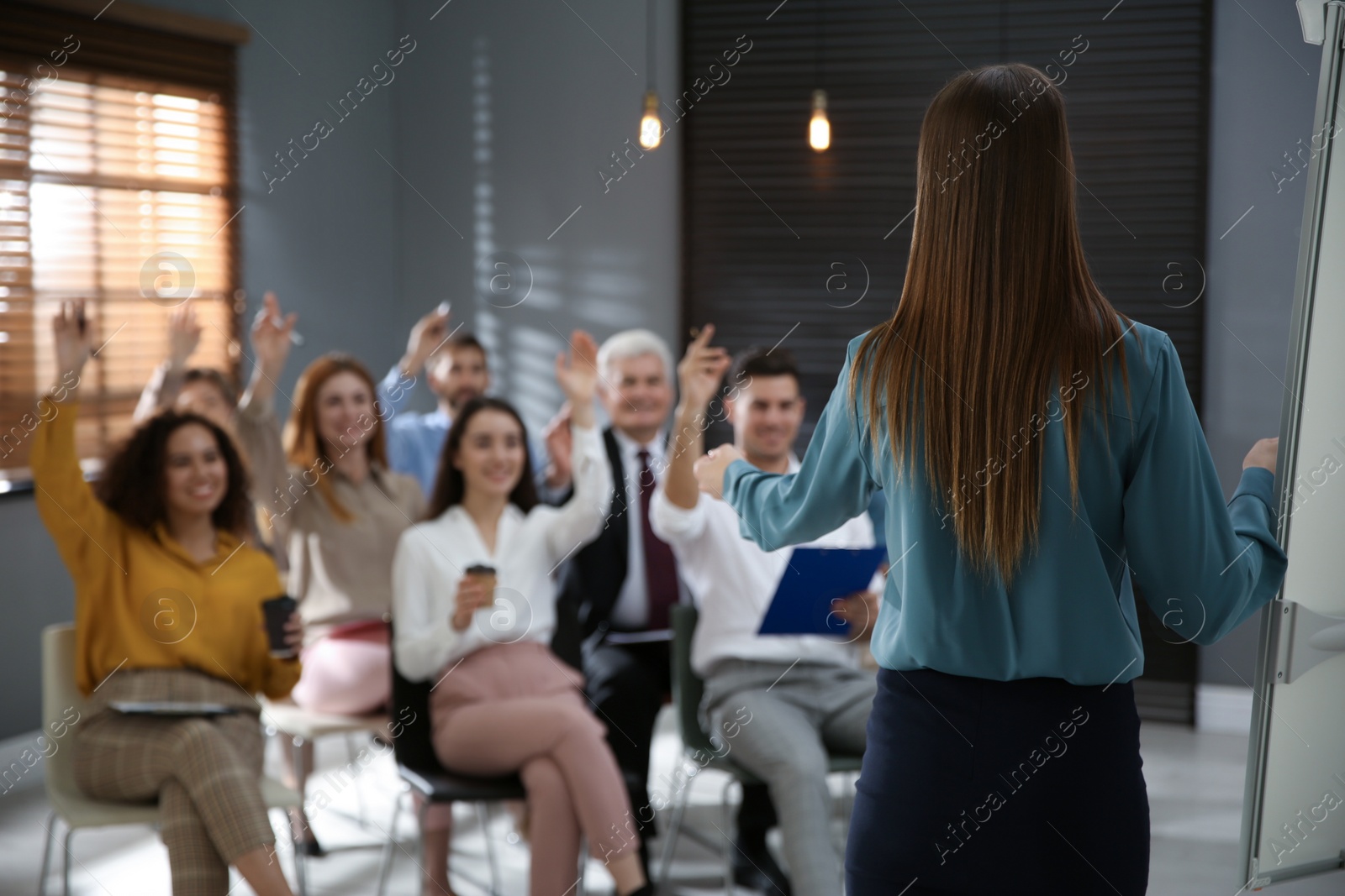 Photo of Business trainer answering questions at seminar in conference hall