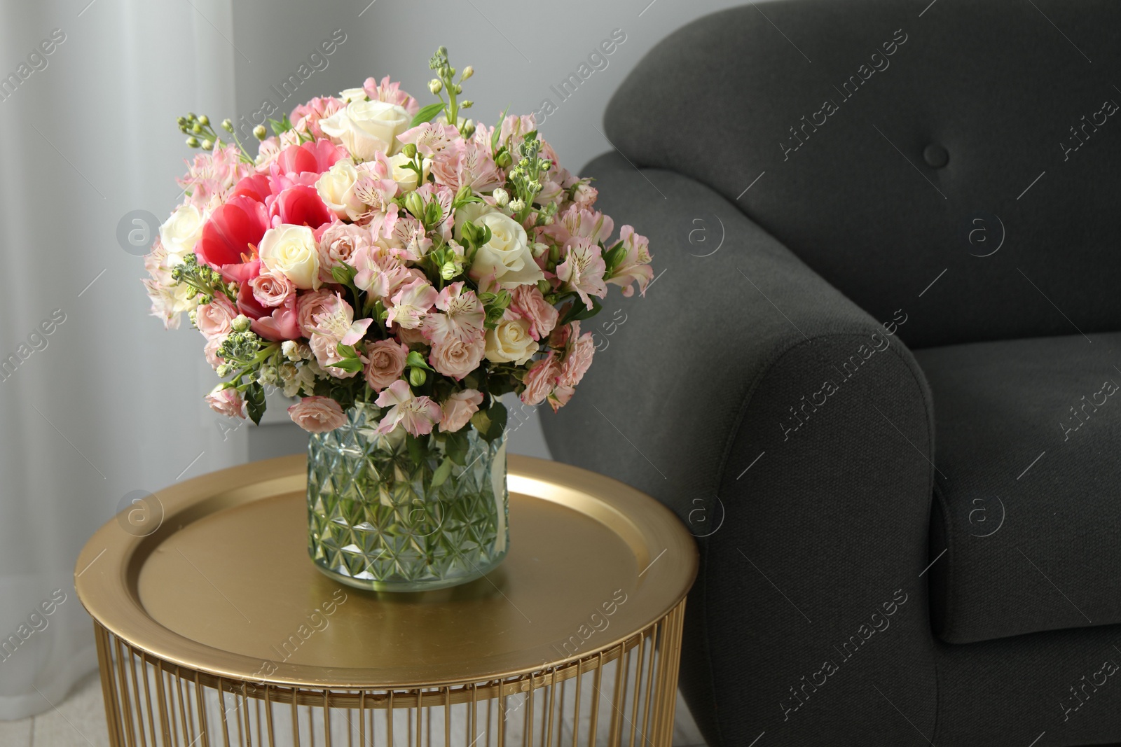 Photo of Beautiful bouquet of fresh flowers on coffee table in room, space for text