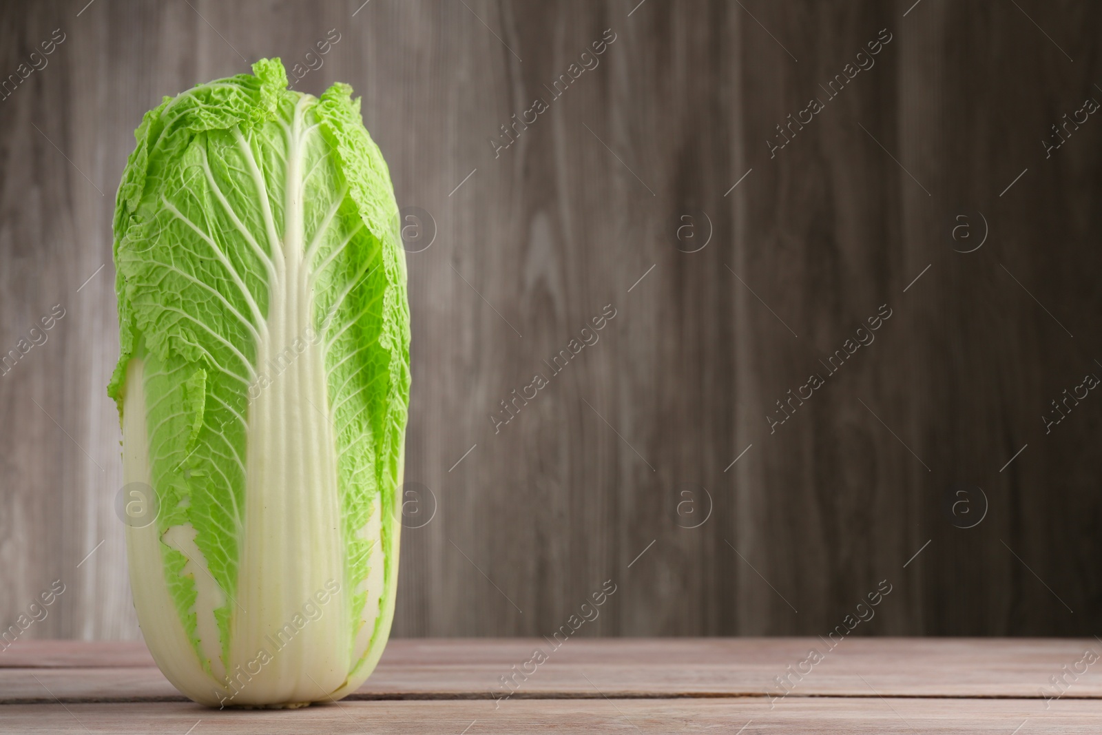 Photo of Fresh ripe Chinese cabbage on wooden table, space for text