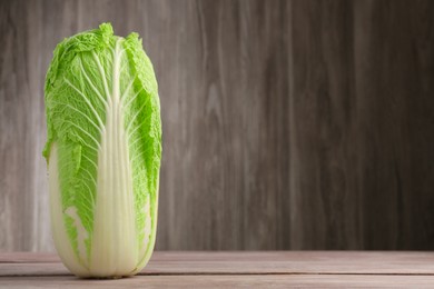 Photo of Fresh ripe Chinese cabbage on wooden table, space for text