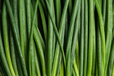 Fresh green spring onions as background, top view