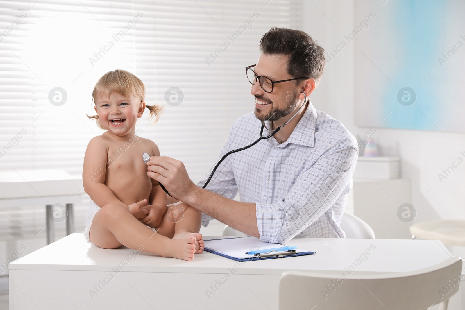 Photo of Pediatrician examining baby with stethoscope in clinic