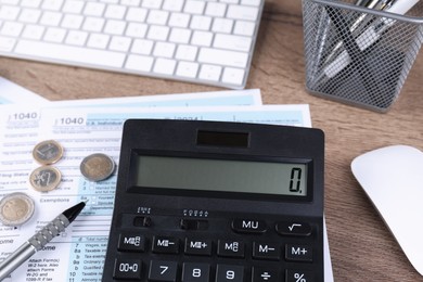 Tax accounting. Calculator, documents, coins, keyboard and pen on wooden table, closeup