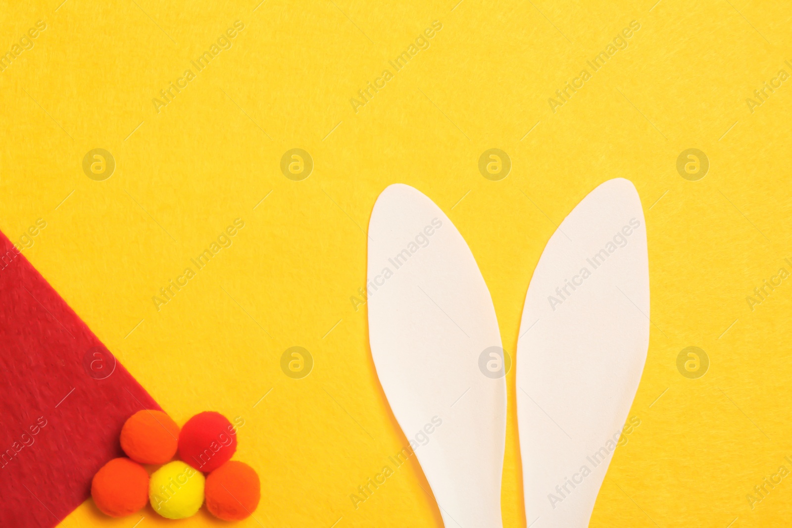 Photo of Flat lay composition of funny Easter bunny ears on color background, space for text