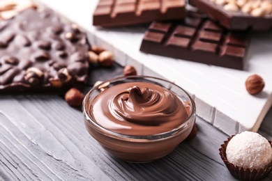 Photo of Bowl with tasty melted chocolate on table