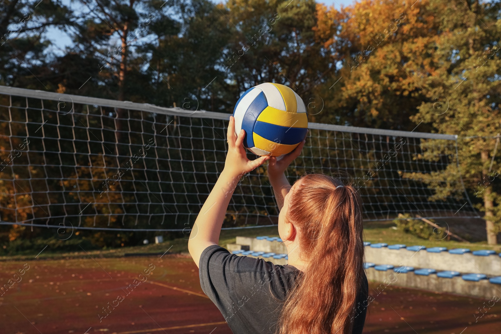 Photo of Girl playing volleyball on sportive court outdoors