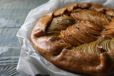 Photo of Delicious apple galette with walnuts on wooden table, closeup