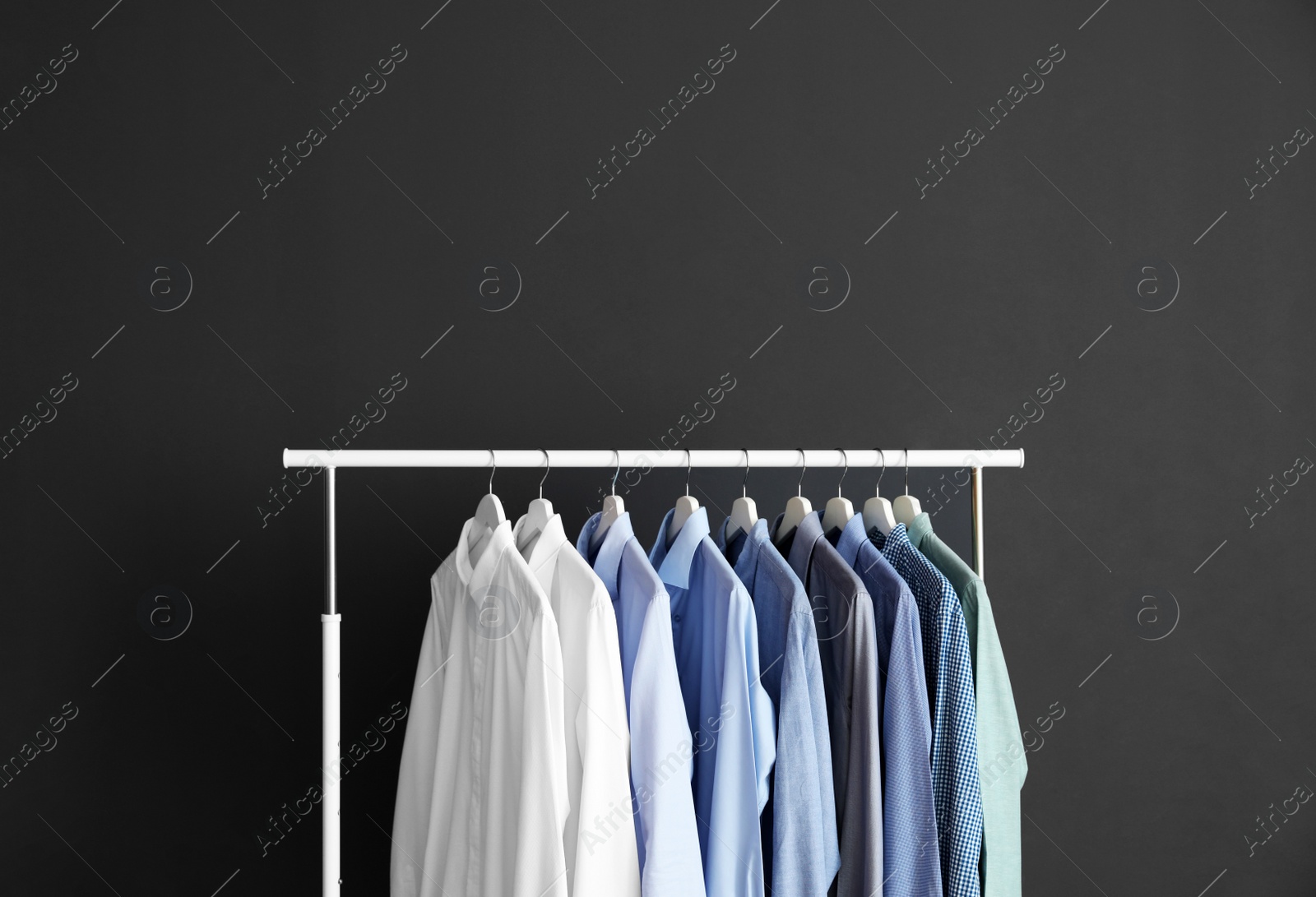 Photo of Wardrobe rack with men's clothes against grey background