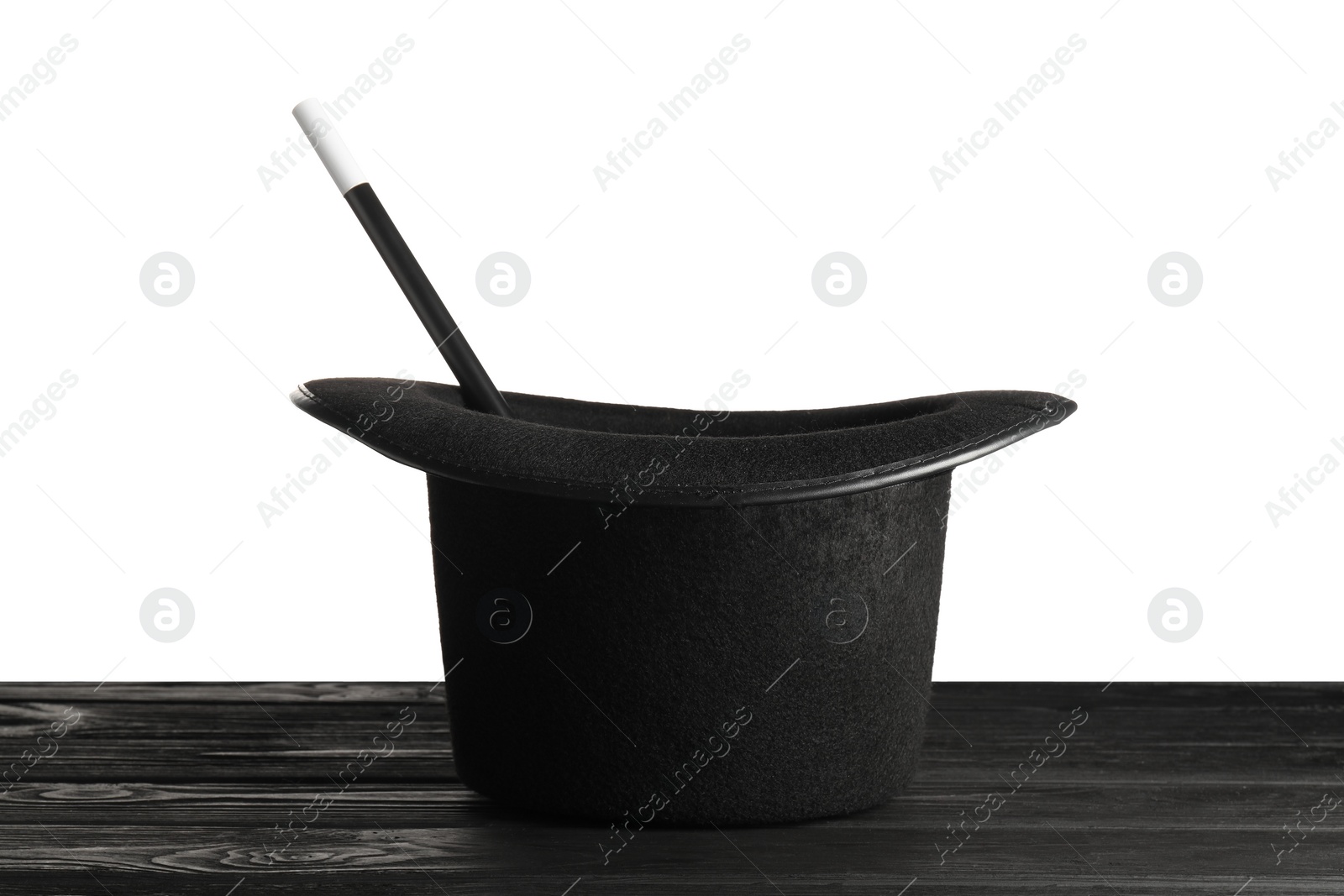 Photo of Magician's hat and wand on wooden table against white background