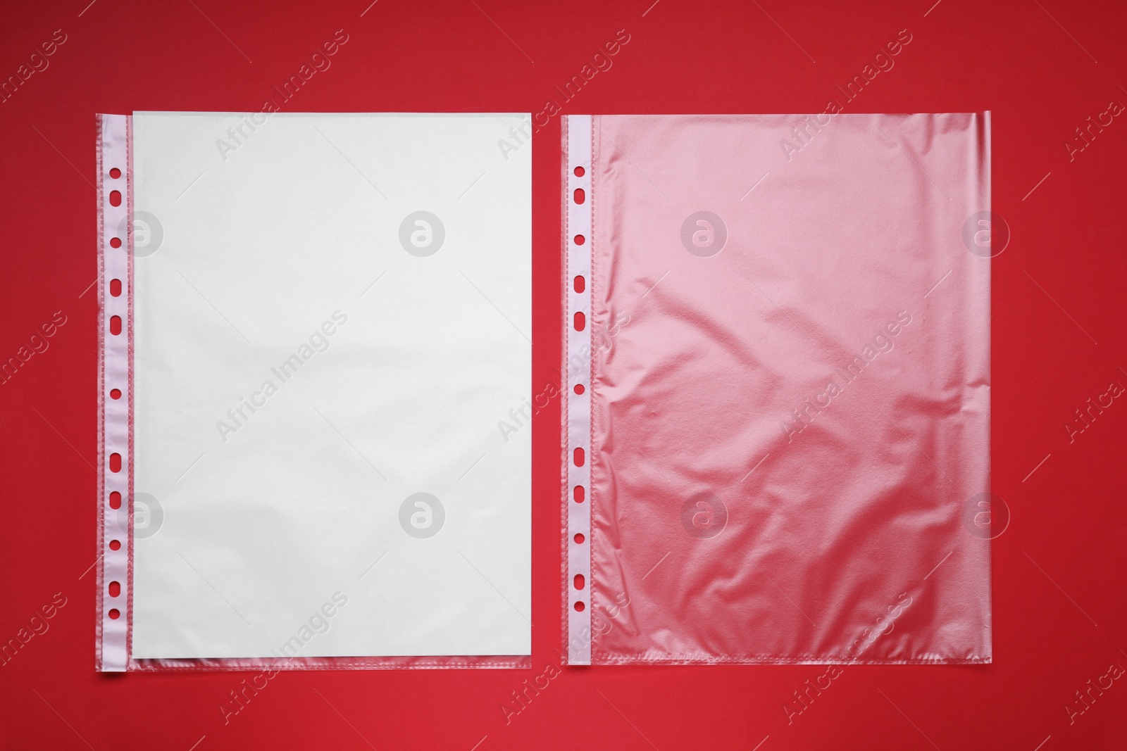 Photo of Punched pockets on red background, flat lay. Space for text