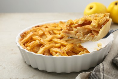 Photo of Cake server with piece of tasty homemade quince pie on light table, closeup