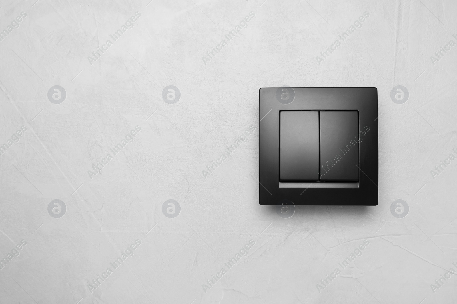 Photo of Black light switch on white background. Space for text