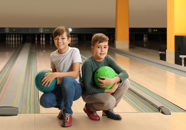 Photo of Happy boys with balls in bowling club