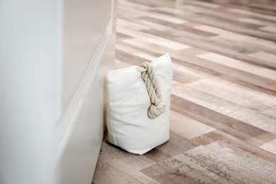 Photo of Stuffed bag holding wooden door at home
