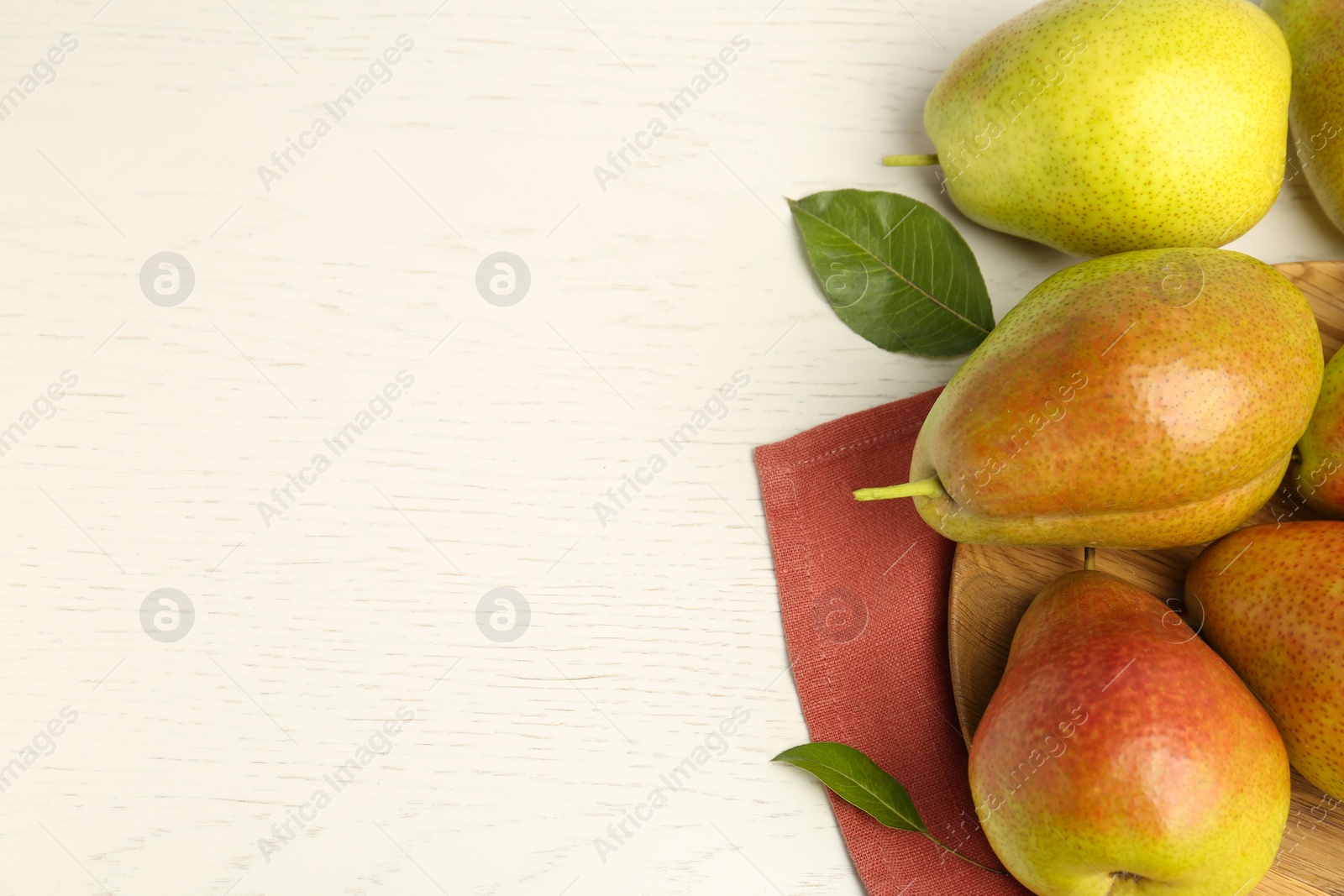 Photo of Ripe juicy pears on white wooden table, flat lay. Space for text