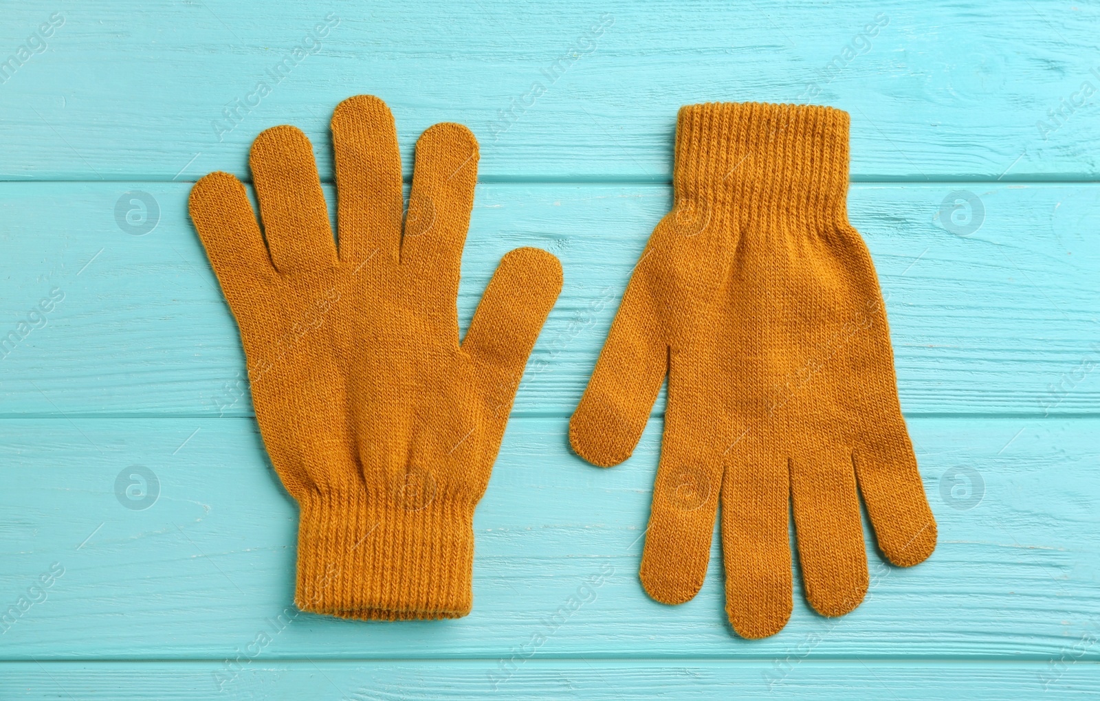 Photo of Stylish gloves on turquoise wooden background, flat lay