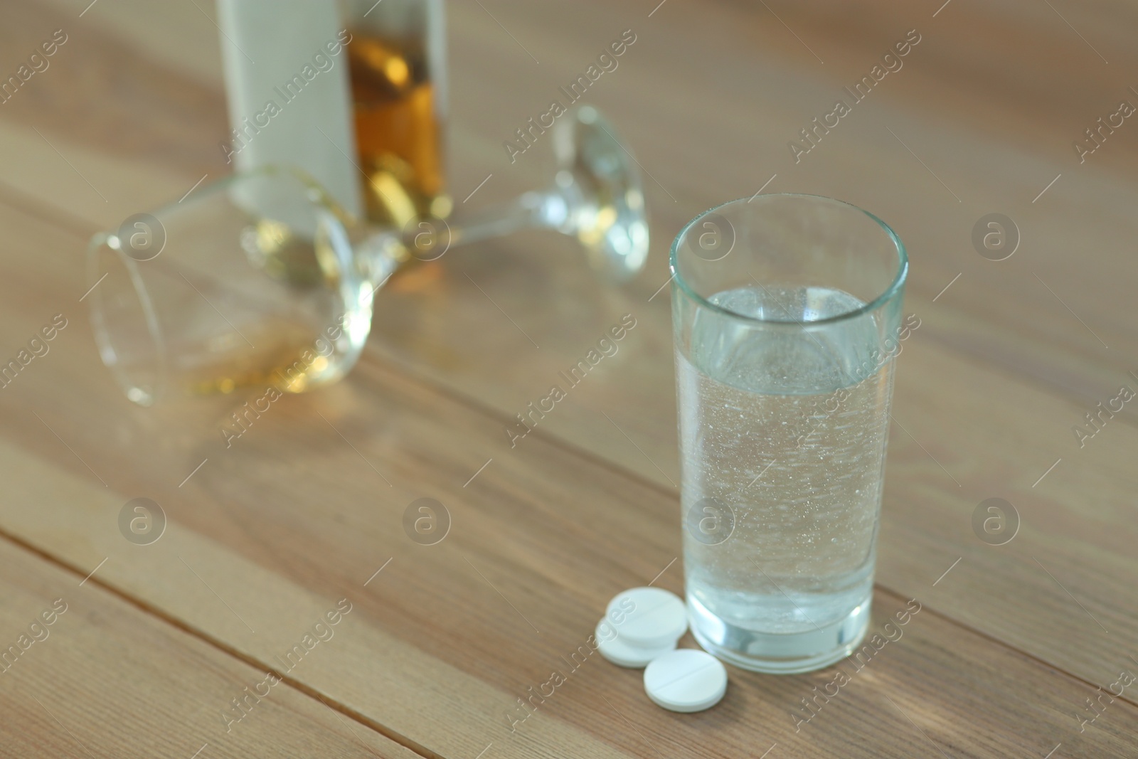 Photo of Glass of water and pills on table indoors, space for text. Hangover remedy