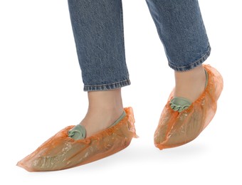 Photo of Woman wearing shoe covers onto her mules against white background, closeup