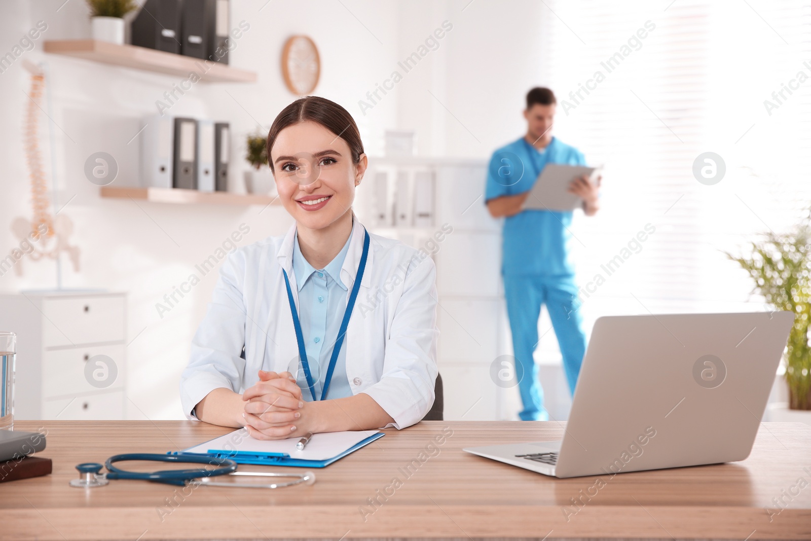 Photo of Portrait of female doctor at table in modern clinic