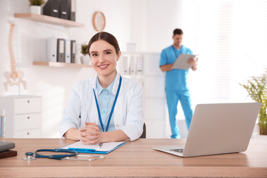 Photo of Portrait of female doctor at table in modern clinic