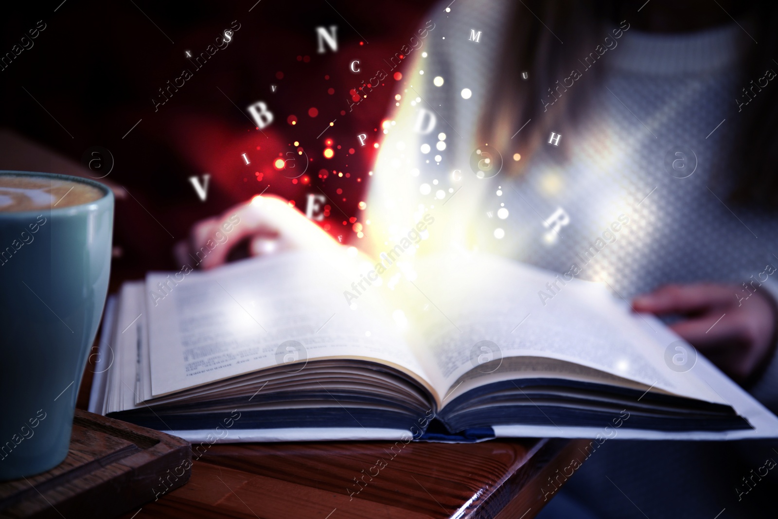 Image of Woman reading shiny magic book with letters flying over it, closeup