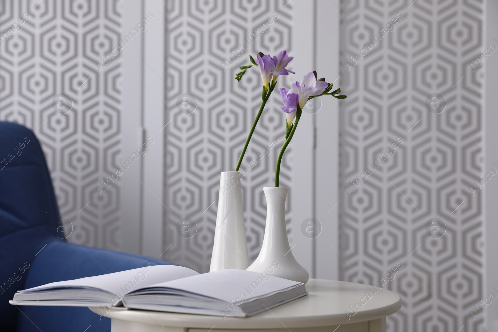 Photo of Beautiful spring freesia flowers on white table in room