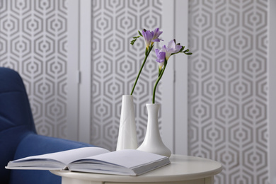 Beautiful spring freesia flowers on white table in room