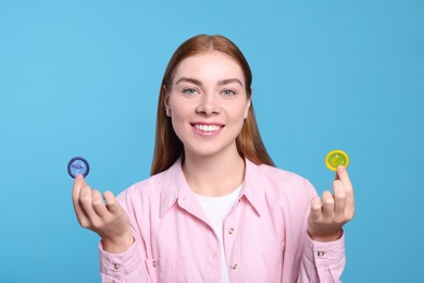 Woman holding condoms on turquoise background. Safe sex