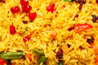 Photo of Tasty rice pilaf with vegetables as background, closeup