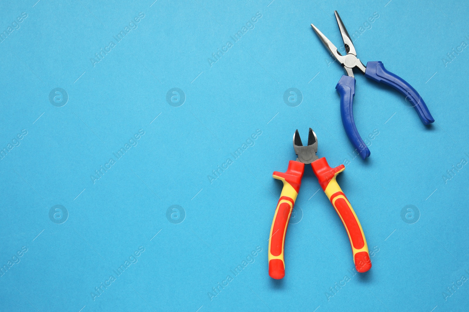 Photo of Pliers on light blue background, flat lay. Space for text