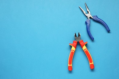 Pliers on light blue background, flat lay. Space for text