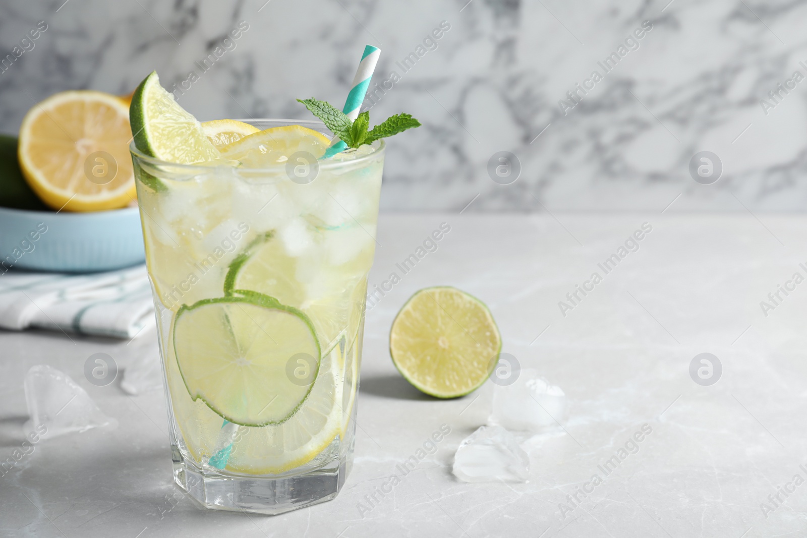 Photo of Delicious lemonade with soda water and mint on light grey table, space for text. Fresh summer cocktail