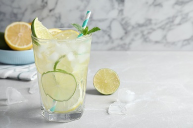 Delicious lemonade with soda water and mint on light grey table, space for text. Fresh summer cocktail