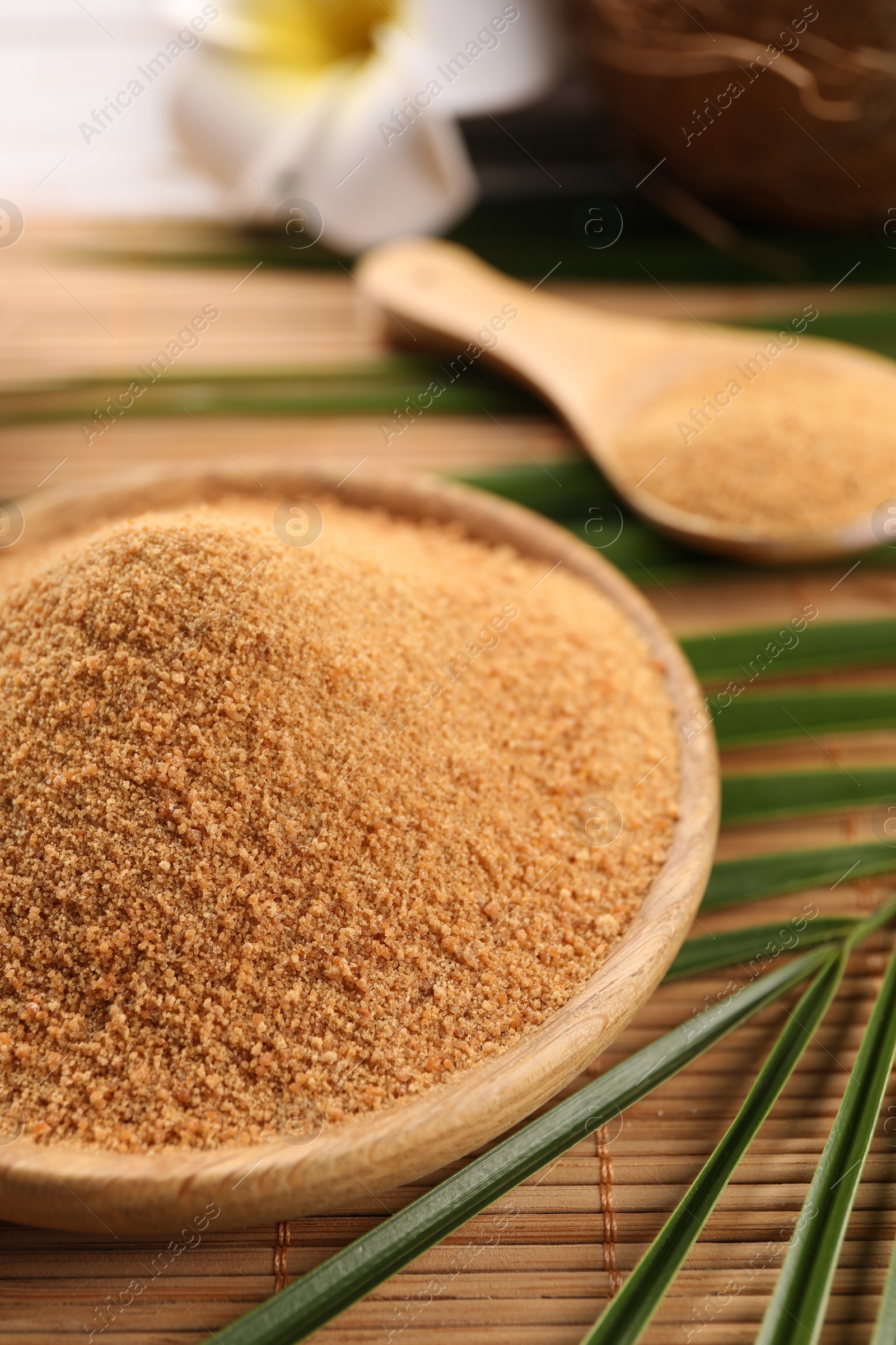 Photo of Coconut sugar and palm leaves on bamboo mat, closeup