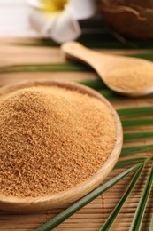 Photo of Coconut sugar and palm leaves on bamboo mat, closeup