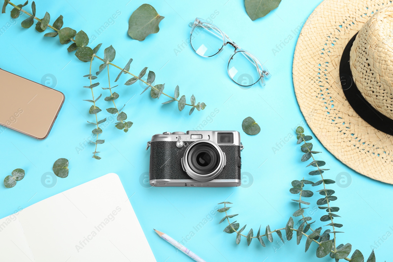 Photo of Flat lay composition with camera for professional photographer and accessories on light blue background