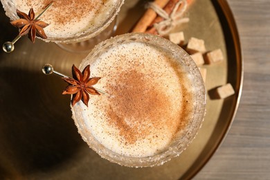 Delicious eggnog with cinnamon and anise on wooden table, flat lay. Space for text