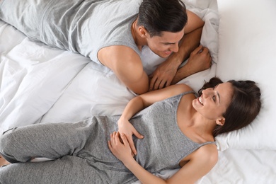 Photo of Lovely young couple resting on large bed, above view