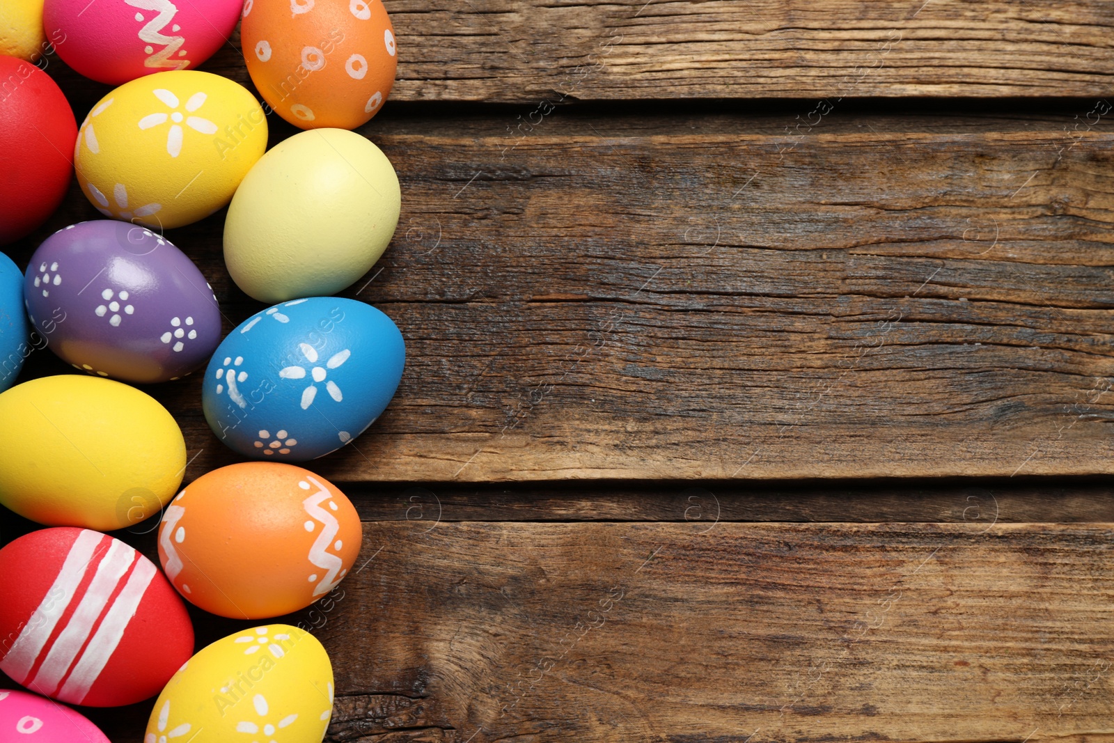 Photo of Colorful Easter eggs on wooden background, flat lay. Space for text