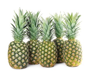 Many delicious ripe pineapples on white background
