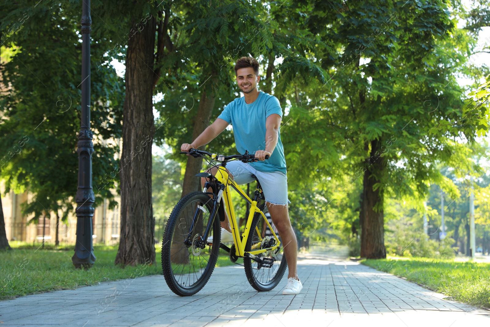 Photo of Handsome young man with bicycle on city street